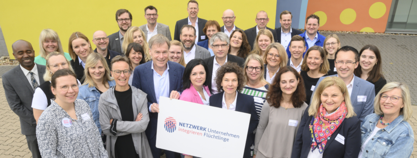 Gruppenfoto der Regionalbotschafter vor dem temps Schulungszentrum in Neustadt. Die Botschaft: Es braucht eine ganzheitliche Unterstützung der Geflüchteten